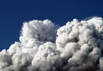 Majestic cumulus clouds forming a dramatic skyscape with a vibrant blue sky background. HD wallpaper