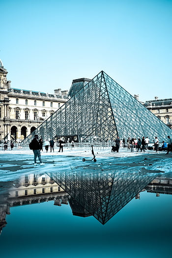 Iconic glass pyramid of the Louvre Museum in Paris reflecting in a pool, showcasing classic architecture. HD phone wallpaper