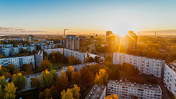 Aerial view of a cityscape at sunrise with autumn foliage and modern buildings. HD wallpaper