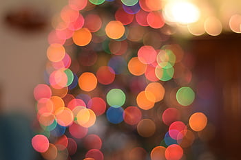 Vibrant bokeh of Christmas tree lights creating a festive atmosphere. HD wallpaper