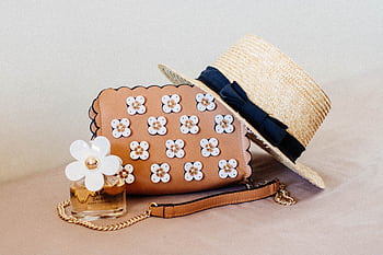 Chic ensemble featuring a floral handbag, straw hat, and perfume, perfect for summer fashion. HD wallpaper
