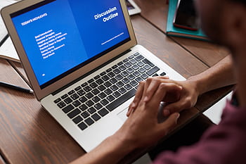 A person viewing a business presentation on a laptop screen, ideal for online learning and work settings. HD wallpaper