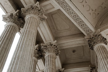 Low-angle view of ornate Corinthian columns showcasing intricate classical architecture. HD wallpaper