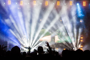 Vibrant nightclub concert with cheering crowd and dazzling spotlights. HD wallpaper