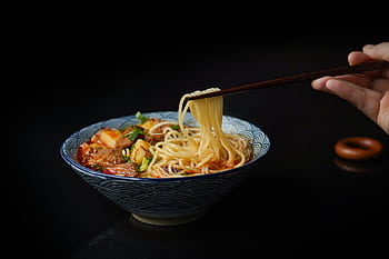 Mouth-watering Asian noodle soup with vegetables and meat, captured close up with chopsticks. HD wallpaper