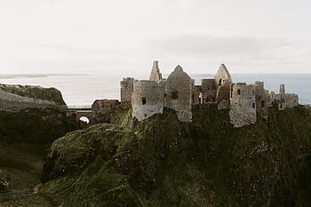 Explore the captivating ruins of Dunluce Castle overlooking the sea in Northern Ireland. HD wallpaper