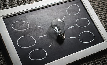 Chalkboard with a light bulb symbolizing ideas and creativity. Perfect for education themes. HD wallpaper