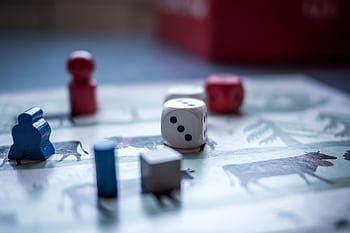 Close-up view of board game pieces and dice on a game board. Perfect for recreation and strategy themes. HD wallpaper