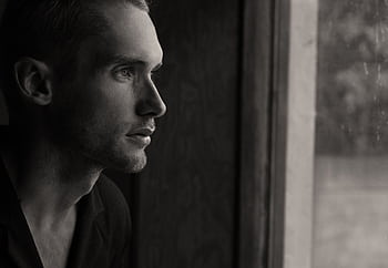 Side profile portrait of a man gazing out a window in black and white. HD wallpaper