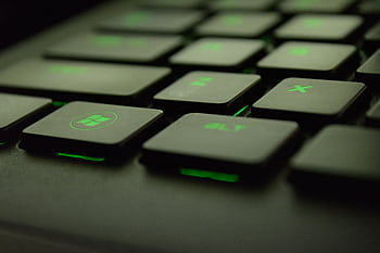 Detailed view of illuminated backlit keyboard keys with green lighting for gaming and tech use. HD wallpaper