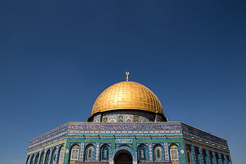 The stunning Dome of the Rock with its golden dome under a clear blue sky in Jerusalem. HD wallpaper