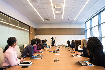 Business meeting with diverse team discussing projects in a modern conference room. HD wallpaper