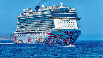 A colorful cruise ship sailing on the open sea under a clear blue sky. Ideal for tourism and travel themes. HD wallpaper