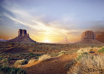 Breathtaking view of Monument Valley's iconic rock formations at sunset, showcasing vivid desert landscape. HD wallpaper