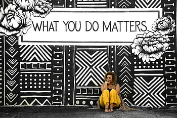 A woman sitting against a motivational mural reading 'What You Do Matters' in Birmingham, AL. HD wallpaper