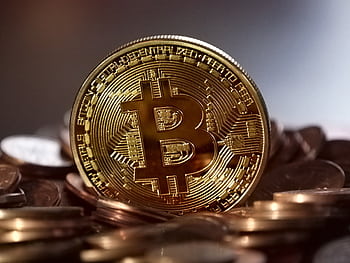 Close-up of a digital cryptocurrency Bitcoin coin placed on a pile of coins. HD wallpaper