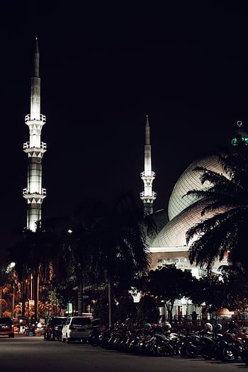 Beautiful night view of a mosque with illuminated minarets, capturing religious architecture. HD phone wallpaper