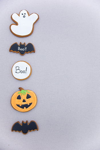Halloween-themed cookies featuring ghost, bats, and pumpkin shapes with copy space. HD phone wallpaper