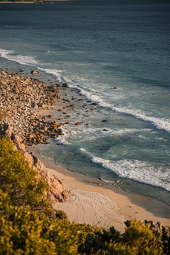 A stunning view of the rocky coastline and turquoise ocean waves in Cape Town, South Africa. HD phone wallpaper