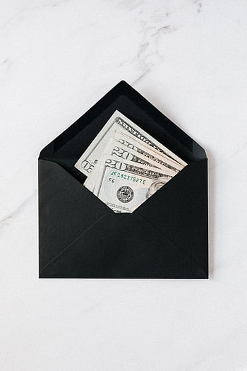 Elegant black envelope containing US dollar bills, placed on a marble surface. HD phone wallpaper