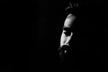 Captivating black and white portrait highlighting a man's thoughtful expression in deep shadows. HD wallpaper