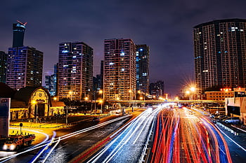 Vibrant long exposure night cityscape in Beijing showcasing urban lights and skyscrapers. HD wallpaper