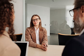 Young woman attending a job interview in a modern office, showcasing confidence and professionalism. HD wallpaper