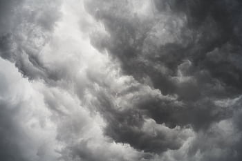 Moody and dramatic storm clouds forming in a turbulent overcast sky. HD wallpaper