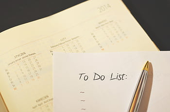 Close-up of a calendar and to-do list on a desk, emphasizing planning and organization. HD wallpaper