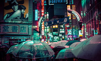 Explore Shibuya's bustling nighttime streets with neon lights and umbrellas amidst the rain in Tokyo, Japan. HD wallpaper