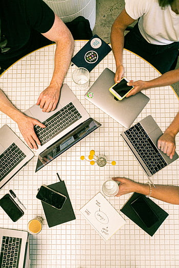 Top view of a team collaborating with laptops, s, and notes in a modern office. HD phone wallpaper