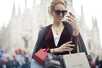Stylish woman with shopping bags takes a selfie near Milan's famous Duomo on a bright day. HD wallpaper