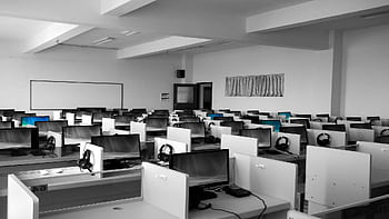 A spacious, empty call center office with rows of desks and computers, ideal for business environments. HD wallpaper