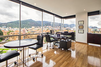 Spacious modern office with a scenic city view through glass windows. HD wallpaper