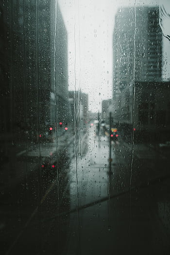 Moody view of a rainy day in Minneapolis, capturing the urban scene through a glass window with raindrops. HD phone wallpaper