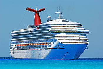 A large cruise ship gliding through clear blue ocean waters on a sunny day. HD wallpaper