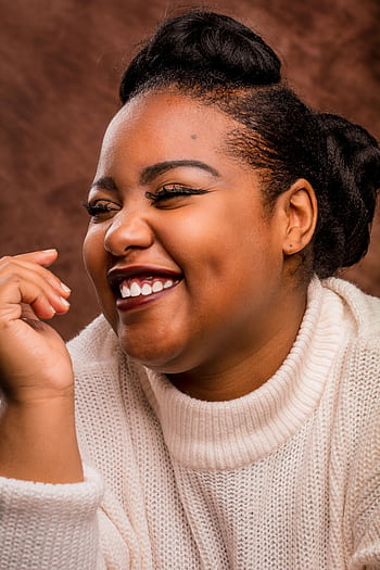 Close-up of a joyful African American woman with elegant hairstyle smiling in a studio setting. HD phone wallpaper