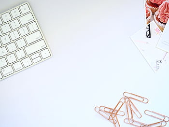Clean and organized workspace featuring a keyboard and rose gold paper clips, perfect for design inspiration. HD wallpaper