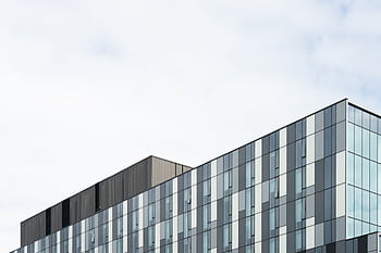 Contemporary glass office building exterior showcasing geometric patterns and modern architecture. HD wallpaper