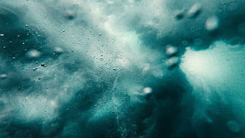 Dynamic underwater scene capturing bubbles and turbulence in a vibrant and abstract blue environment. HD wallpaper