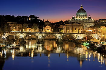 Beautiful view of Saint Peter's Basilica and St. Angelo Bridge in Rome at sunset reflecting in the Tiber River. HD wallpaper