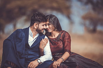 A loving couple sharing a tender moment outdoors, highlighting their romantic connection and stylish attire. HD wallpaper