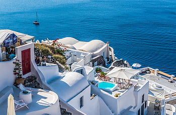 Whitewashed Santorini architecture overlooking the deep blue Aegean Sea. HD wallpaper