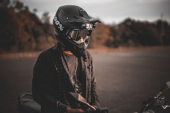 Motorcyclist wearing full-face helmet, enjoying a scenic outdoor ride at sunset. HD wallpaper