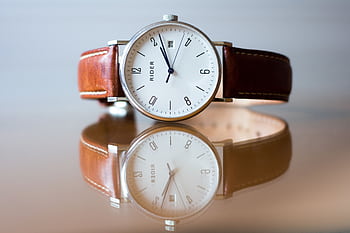 Close-up of a classic analog watch with leather strap and reflection. HD wallpaper