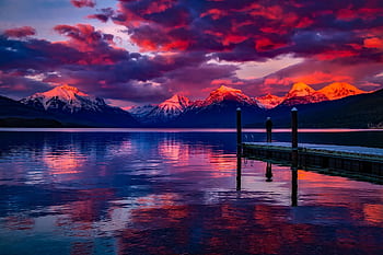 Stunning sunset over a serene lake with colorful sky and majestic mountains. HD wallpaper
