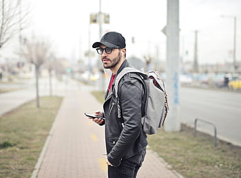 A fashionable young man in Budapest checking his smart on a busy street. HD wallpaper
