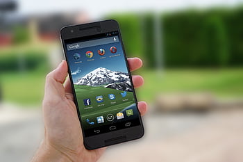 Close-up of a smart in hand displaying social media apps on screen. HD wallpaper