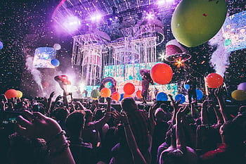 Colorful festival scene with crowd enjoying live performance and vibrant balloon display. HD wallpaper