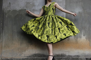 Woman twirling in a vibrant floral dress capturing movement and style. HD wallpaper